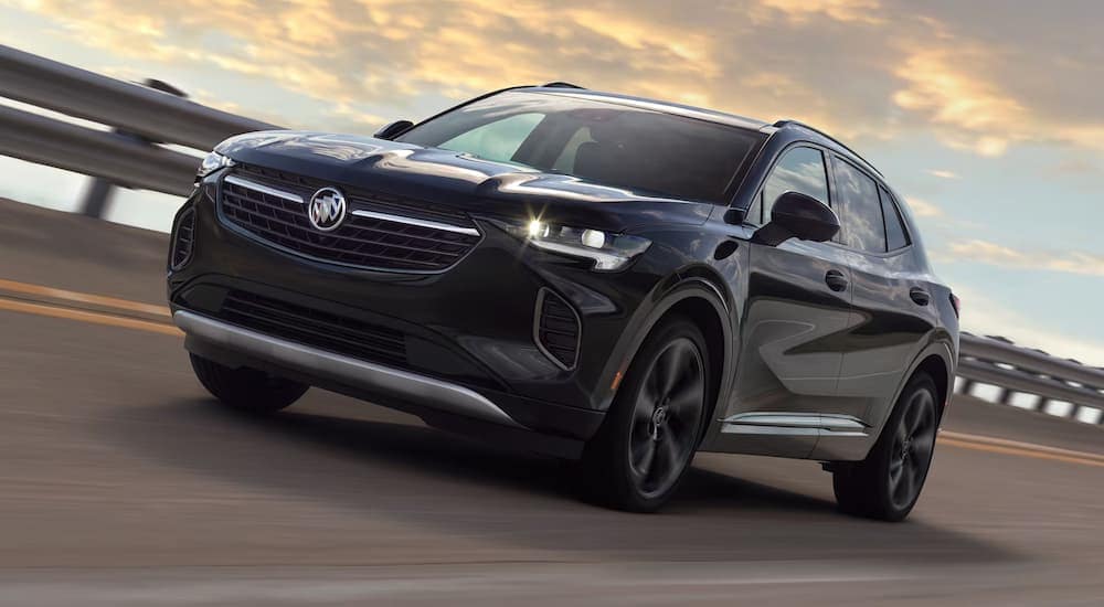 A black 2023 Buick Envision ST driving on an open highway.
