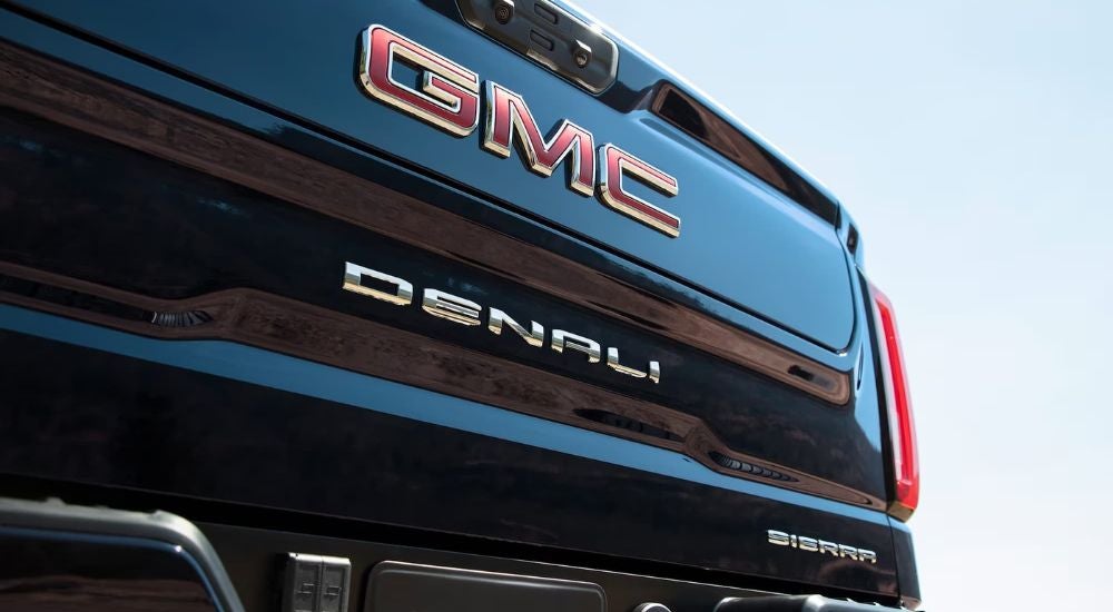 A close-up on the Denali badging on the tailgate of a black 2024 GMC Sierra 1500 Denali.