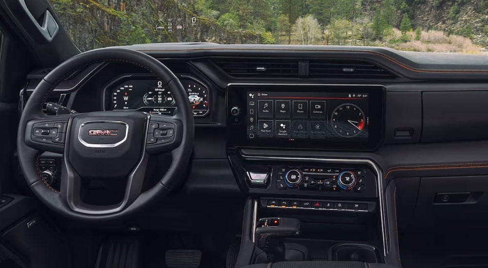 The steering wheel and infotainment screen inside a 2024 GMC Sierra 1500 AT4 for sale.