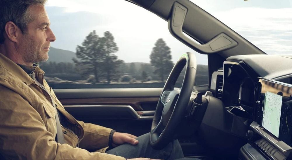 A man sitting in the driver's seat of a 2024 Chevy Silverado 1500 and using Super Cruise.