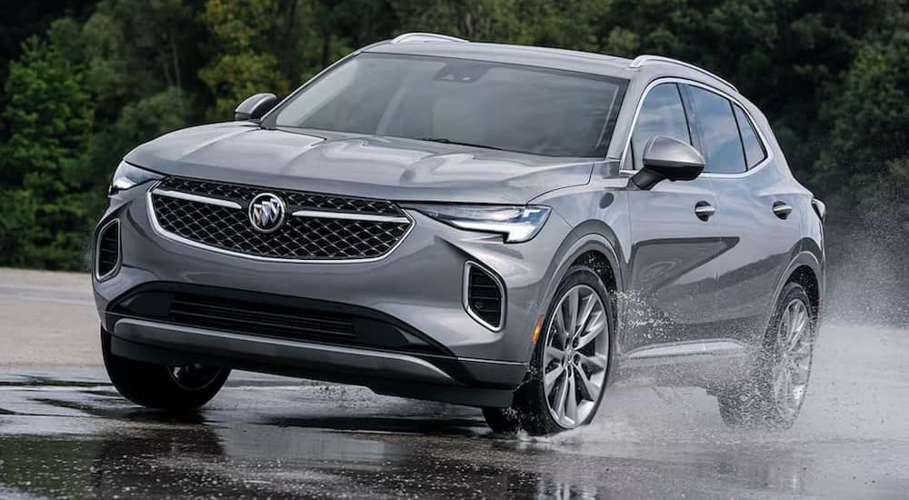 A silver 2023 Buick Envision is shown driving on a puddle after visiting a Buick dealer near Gowrie.