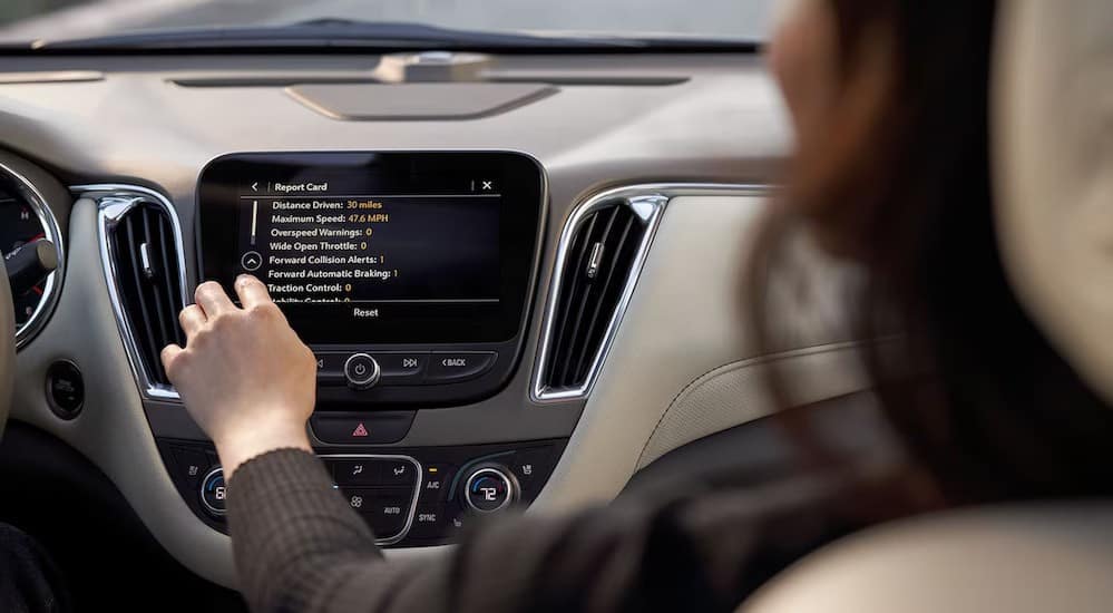 A person is shown utilizing teen driver technology on an infotainment screen.