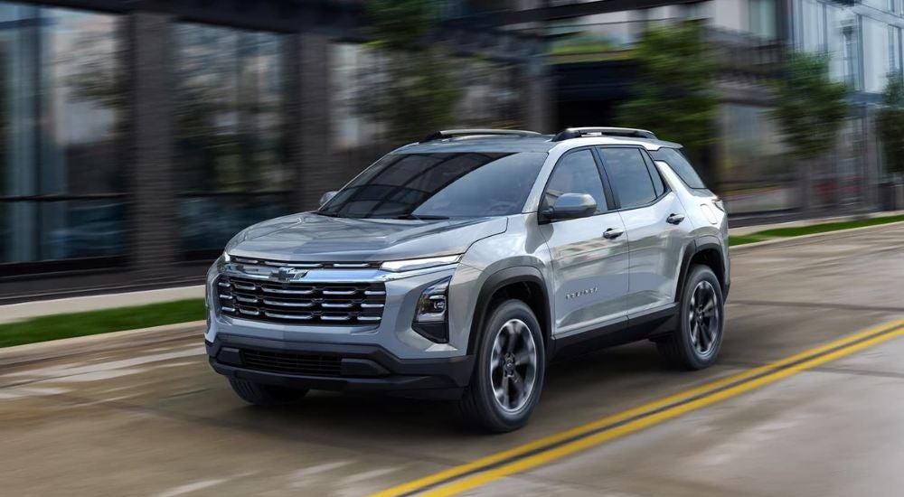 A grey 2025 Chevy Equinox driving from a Chevy dealer near Manson.
