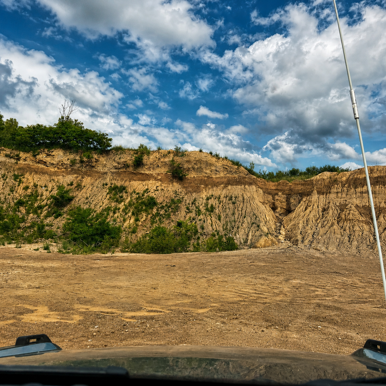 Driver view of sandy cliff trail