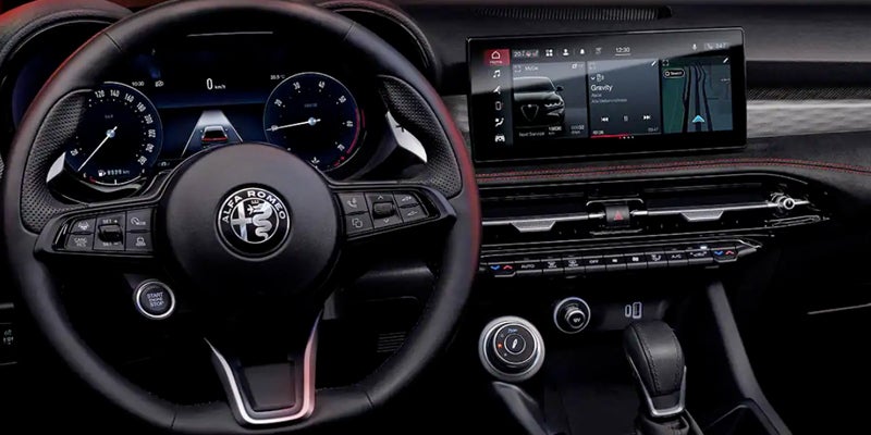 Interior view of a car cockpit with the steering wheel, digital dashboard, and infotainment screen showing music and navigation.