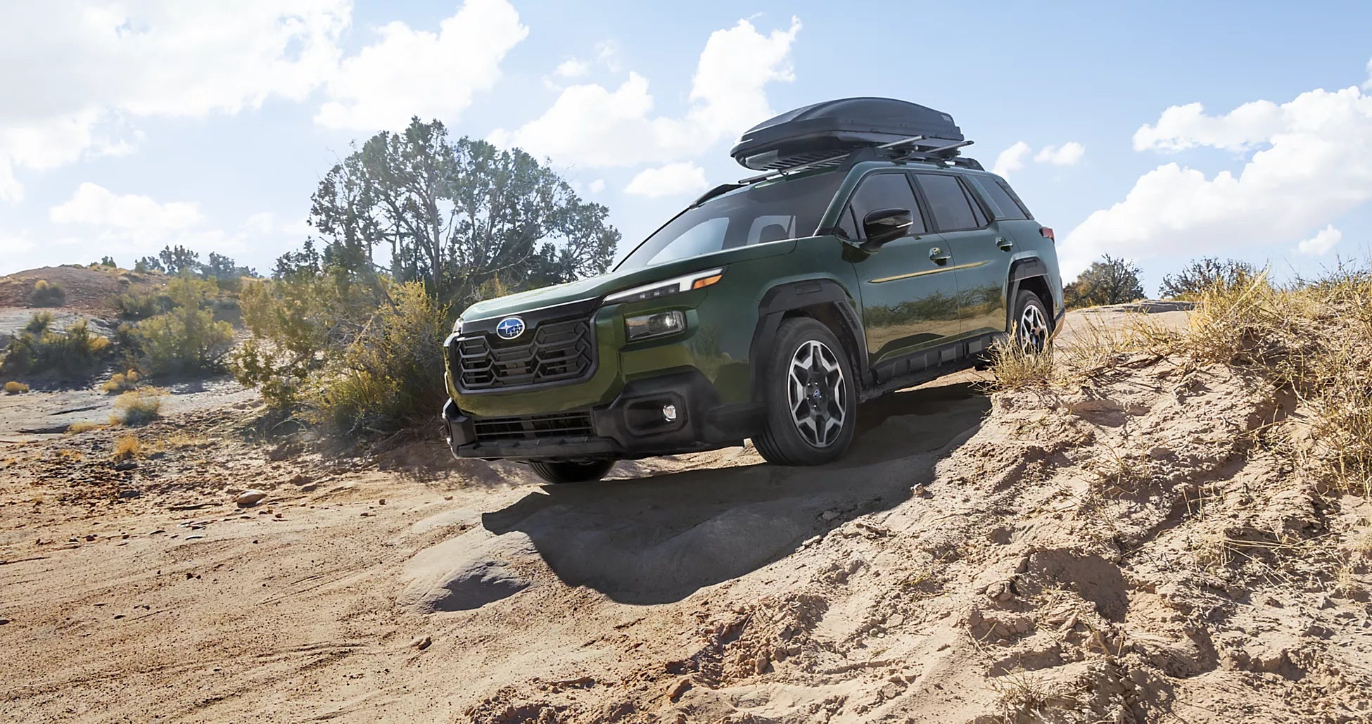 2026 dark green Subaru Outback driving on rocky terrain in Idaho Falls, ID
