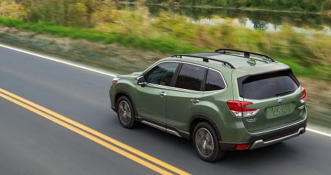 Subaru car driving on road 
