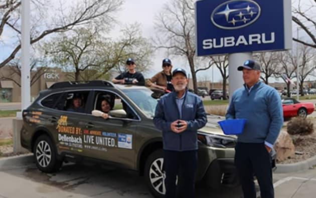 Volunteers loading donation boxes into a Subaru vehicle