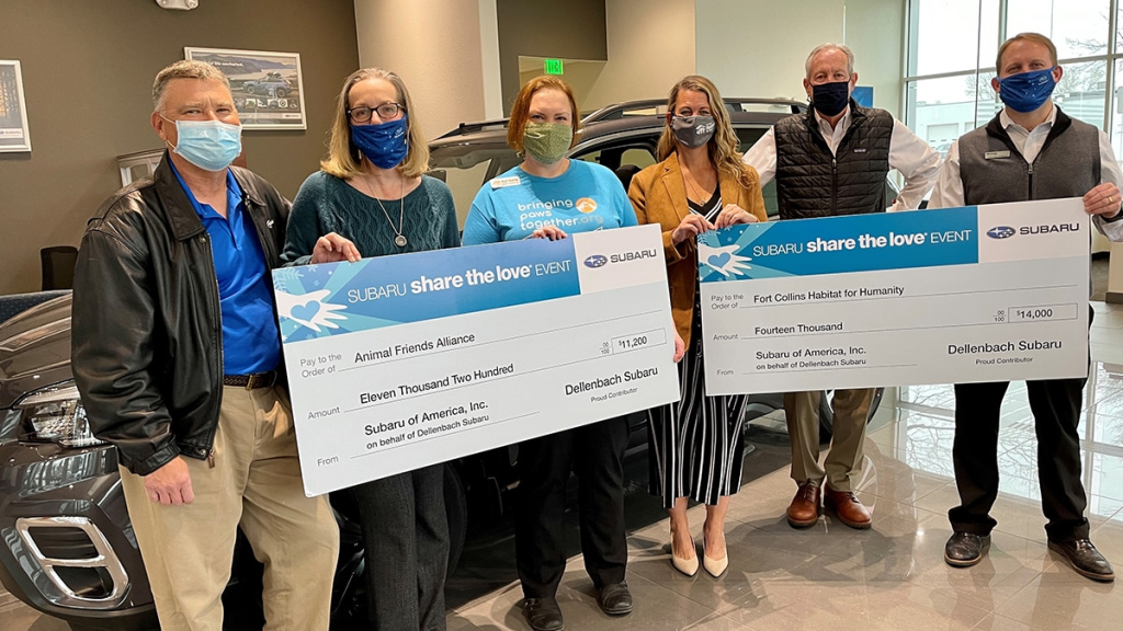 Subaru share love event staff holding check