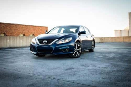 Blue Nissan Altima parked diagonally outside in parking lot