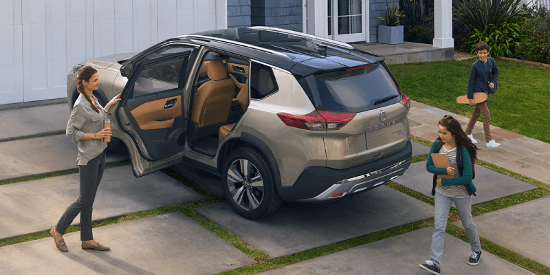 Silver Nissan Rogue in Driveway with Family