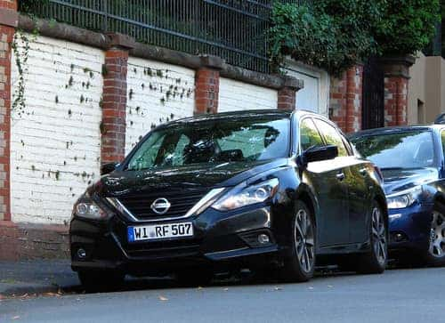 Navy blue 2022 Nissan Altima parallel parked on a street