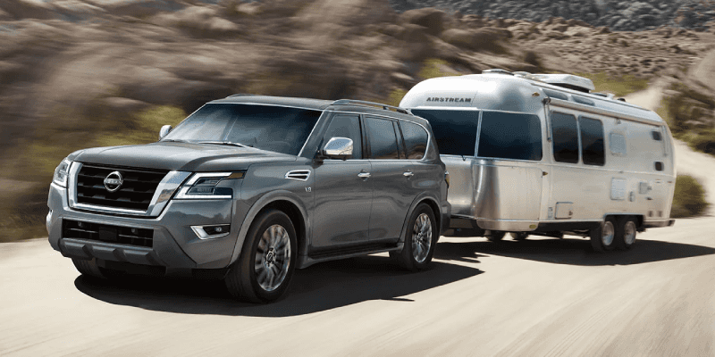 2022 Nissan Armada SUV towing a camper through the dessert