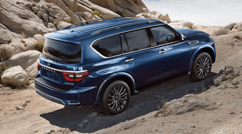 Blue 2022 Nissan Armada driving up rocky terrain
