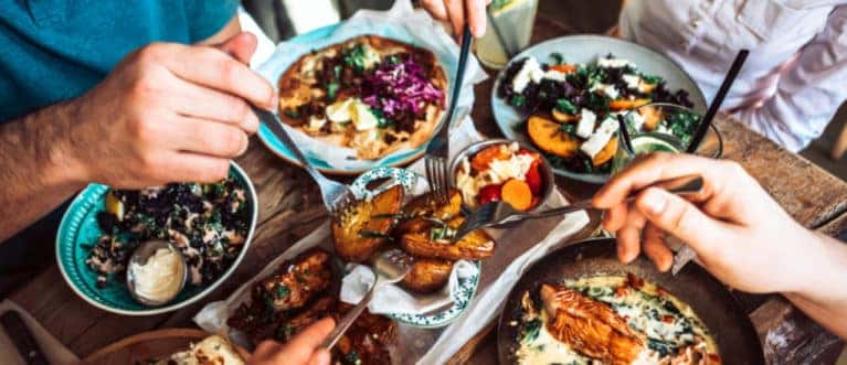 Friends Sharing Many Dishes Around a Table