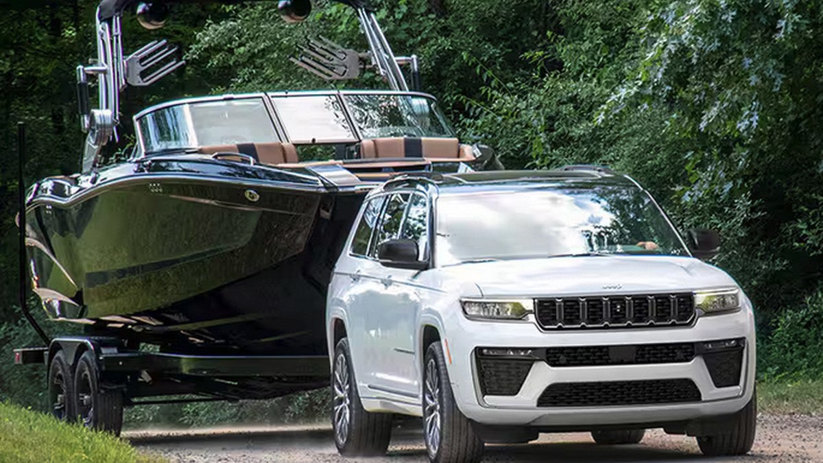 White Jeep Grand Cherokee towing a boat on a road near Sealy Texas