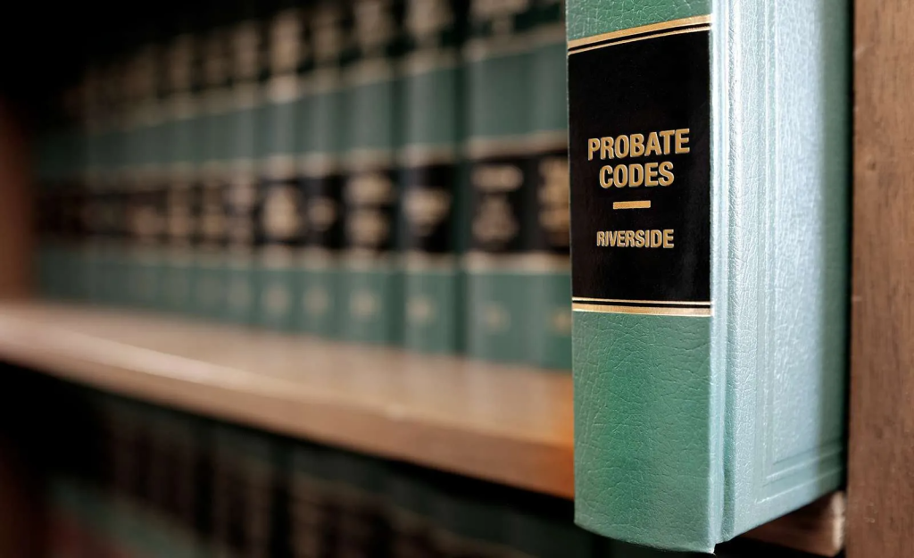 2025 Probate Code changes in Riverside County as represented by a row of law books with one pulled out hat says Probate Codes Riverside
