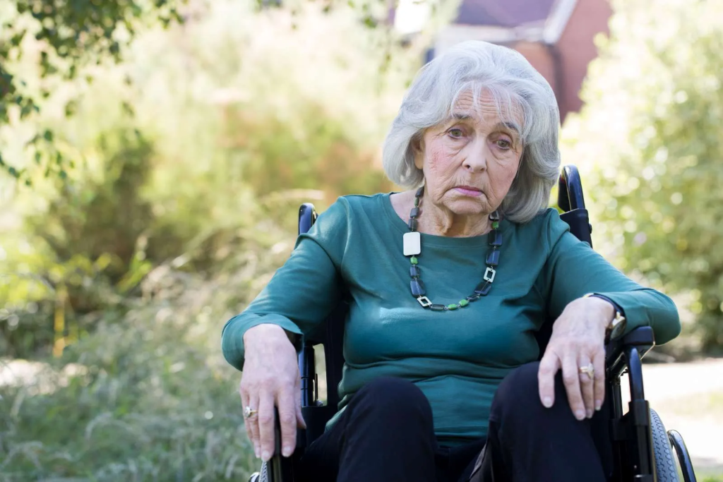 elderly senior woman sitting alone in wheelchair nursing home neglect
