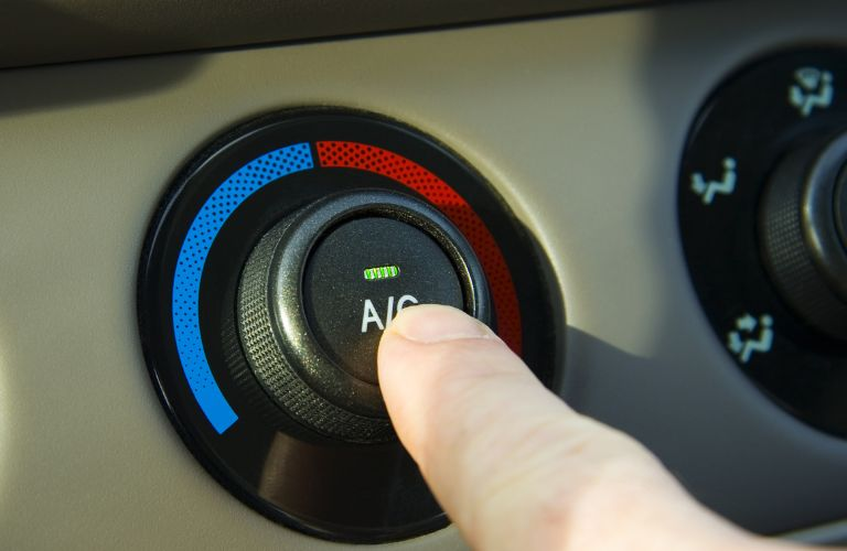 a finger pressing the AC button