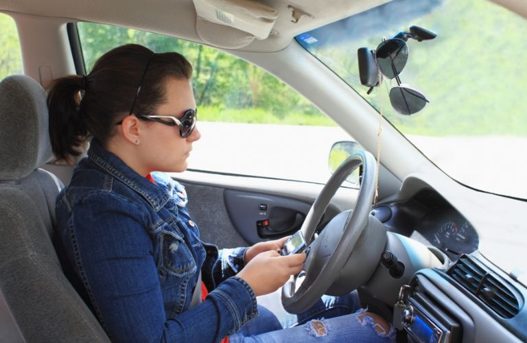 a teen girl texting while driving