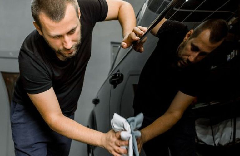 a technician waxing a car