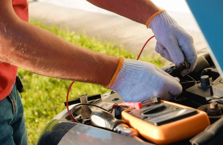 a technician inspecting the battery of a car