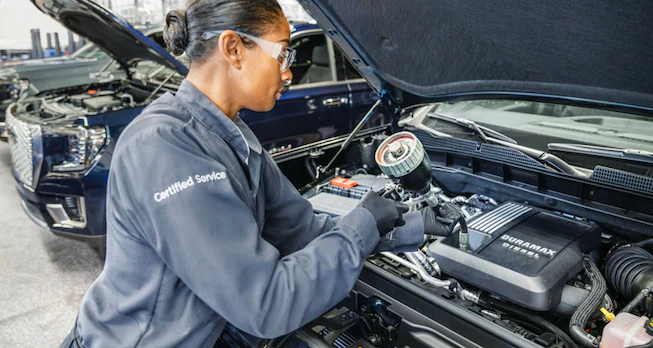 GMC Service technician conducting an oil change.