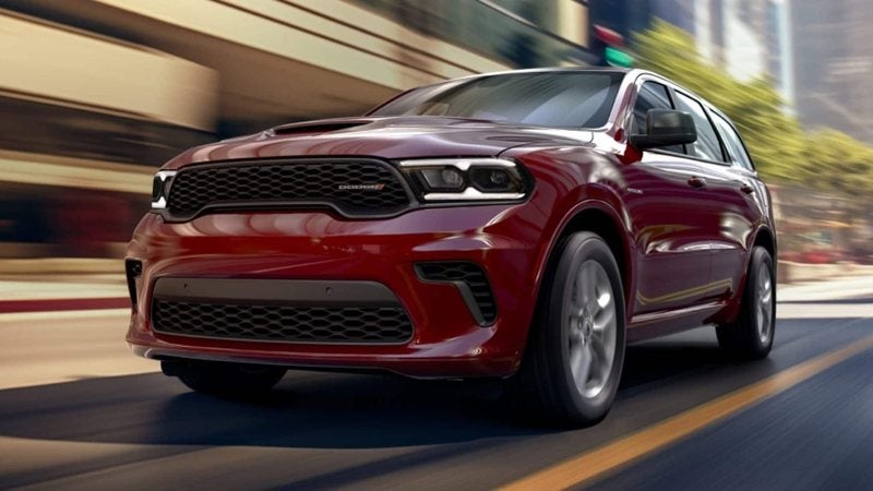 Red 2026 Dodge Durango driving down a city street; Dodge Durango specials at Ross Downing CDJR of Mobile, AL