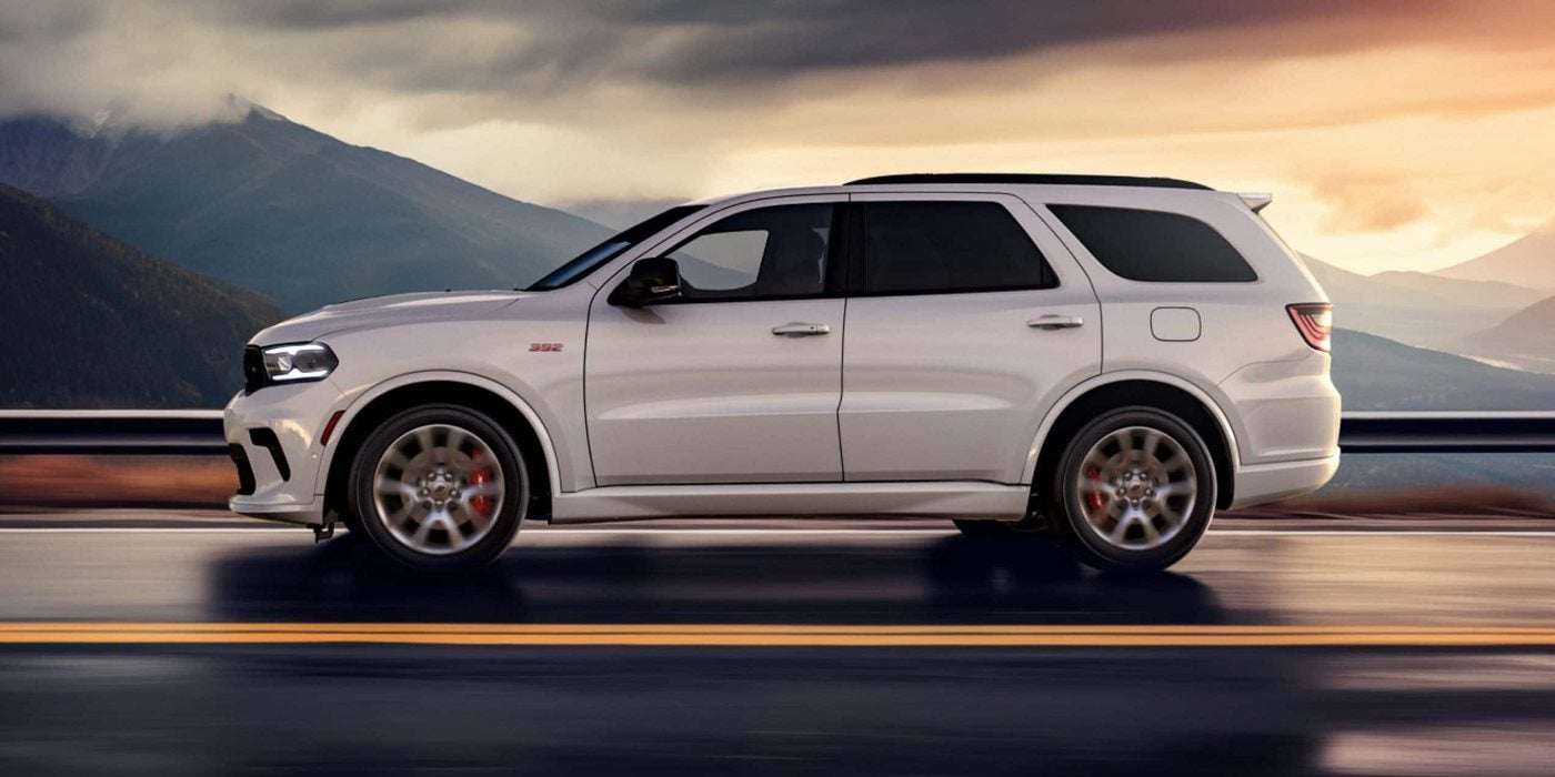 White 2026 Dodge Durango R/T 392 with red brake calipers on a mountain highway; Durango engines and towing at Ross Downing CDJR of Mobile, AL