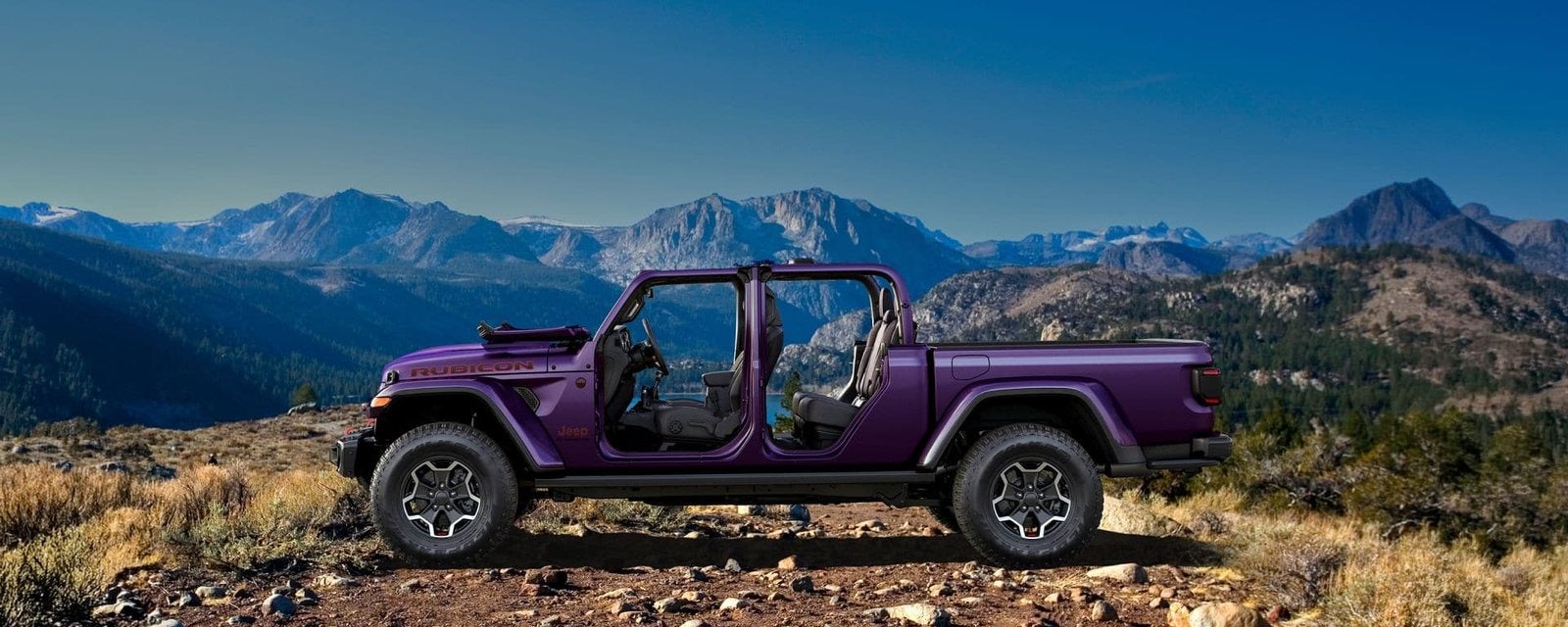 Purple 2027 Jeep Gladiator Rubicon X with its doors and top removed on a mountain overlook; new Jeep Gladiator trucks for sale at Ross Downing CDJR of Mobile, AL