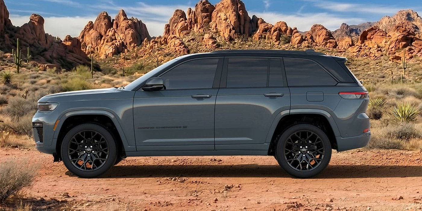 Gray 2027 Jeep Grand Cherokee 2-row SUV in side profile on a desert trail, new at Ross Downing CDJR of Mobile, AL