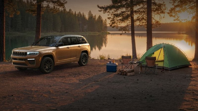 Copper 2027 Jeep Grand Cherokee parked at a lakeside campsite; Grand Cherokee financing at Ross Downing CDJR of Mobile, AL
