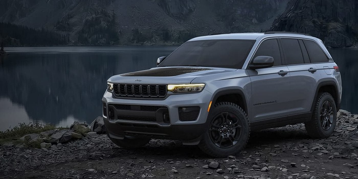Silver 2027 Jeep Grand Cherokee Upland with all-terrain tires on a rocky lakeshore, for sale at Ross Downing CDJR of Mobile, AL