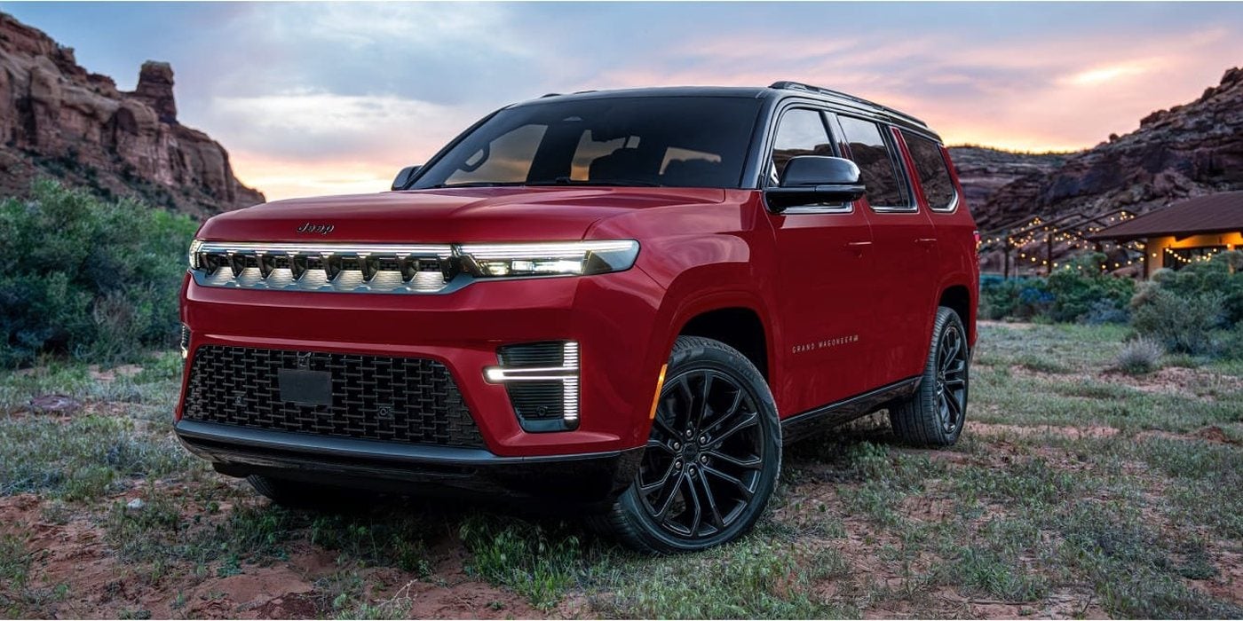 Red 2027 Jeep Grand Wagoneer with its front light bar lit, parked in a canyon at dusk; new at Ross Downing CDJR of Mobile, AL