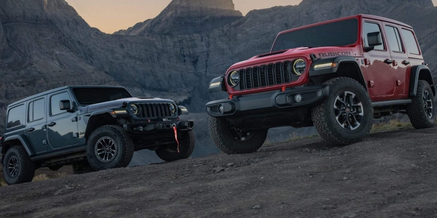 Gray and red 2026 Jeep Wrangler 4-door models on a mountain trail, new at Ross Downing CDJR of Mobile, AL