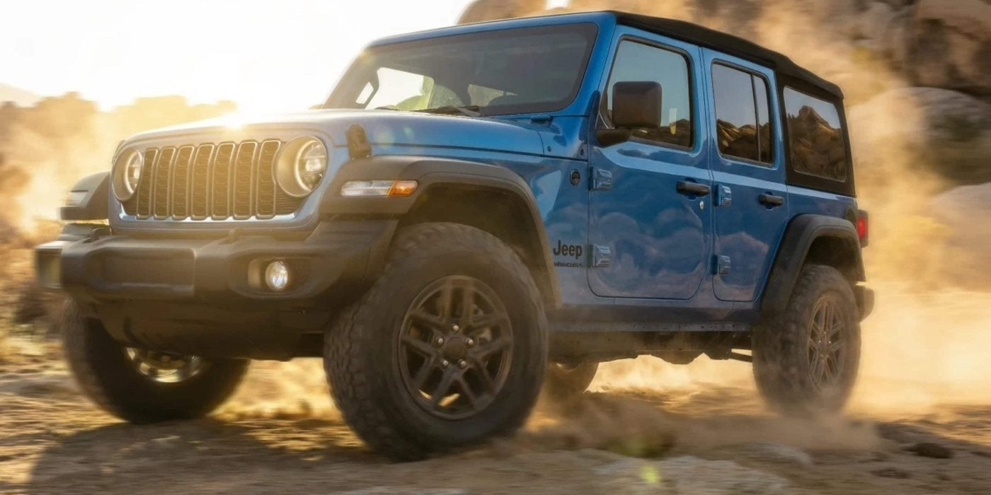 Blue 2026 Jeep Wrangler 4-door kicking up dust on a desert trail, for sale at Ross Downing CDJR of Mobile, AL