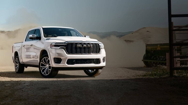 White 2027 Ram 1500 Crew Cab in a cloud of dust; Ram 1500 specials at Ross Downing CDJR of Mobile, AL