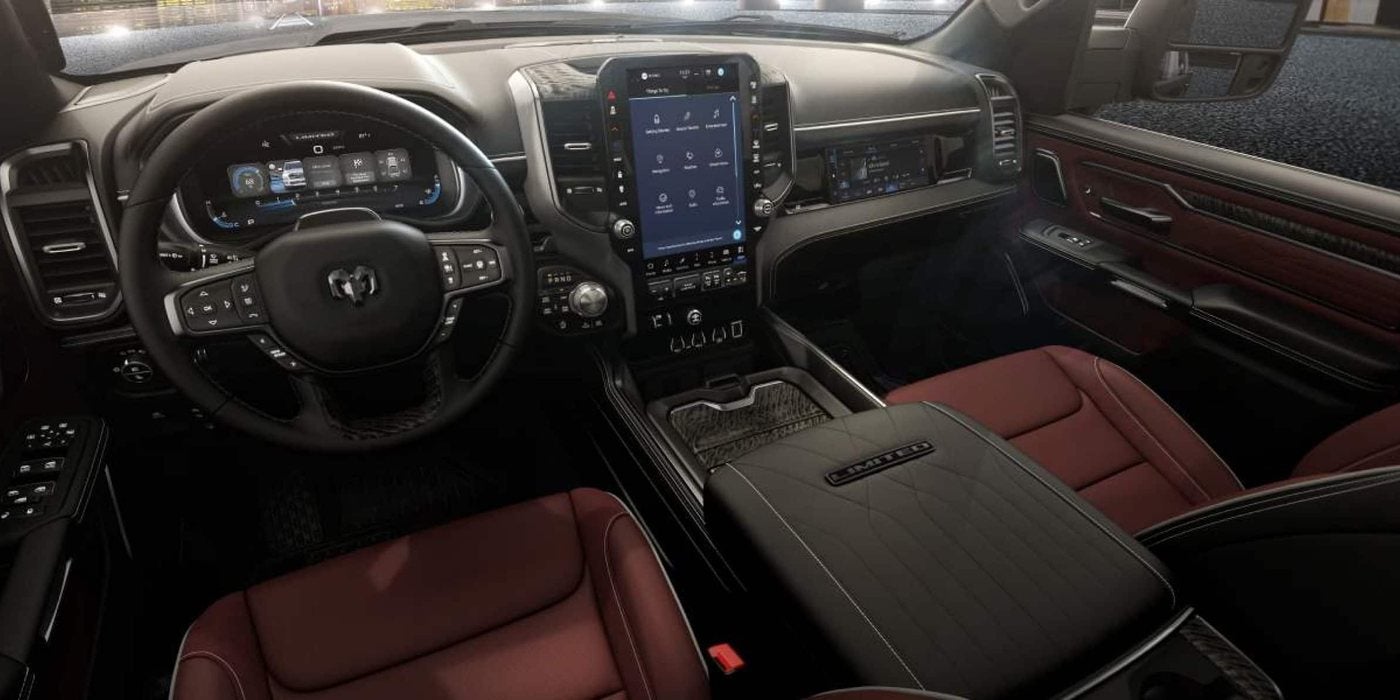 2027 Ram 1500 cabin with a vertical Uconnect touchscreen, digital gauge cluster and red seats, at Ross Downing CDJR of Mobile, AL