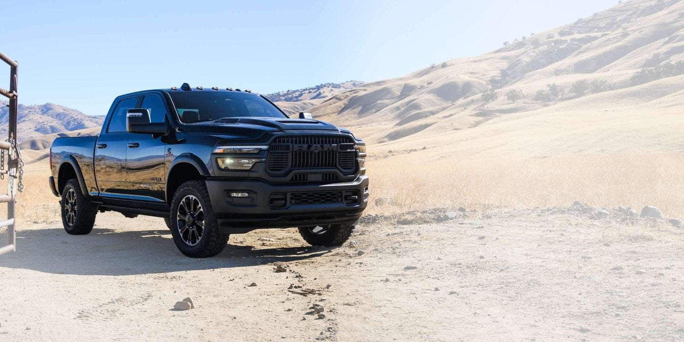 Black 2027 Ram 2500 Crew Cab parked by a ranch gate in a dry grass valley, new at Ross Downing CDJR of Mobile, AL