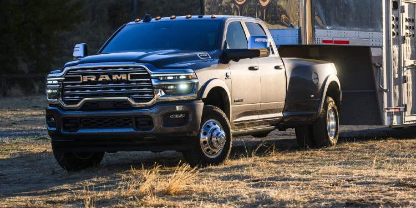 2026 Ram 3500 with dual rear wheels hitched to a livestock trailer at dusk, sold new at Ross Downing CDJR of Mobile, AL