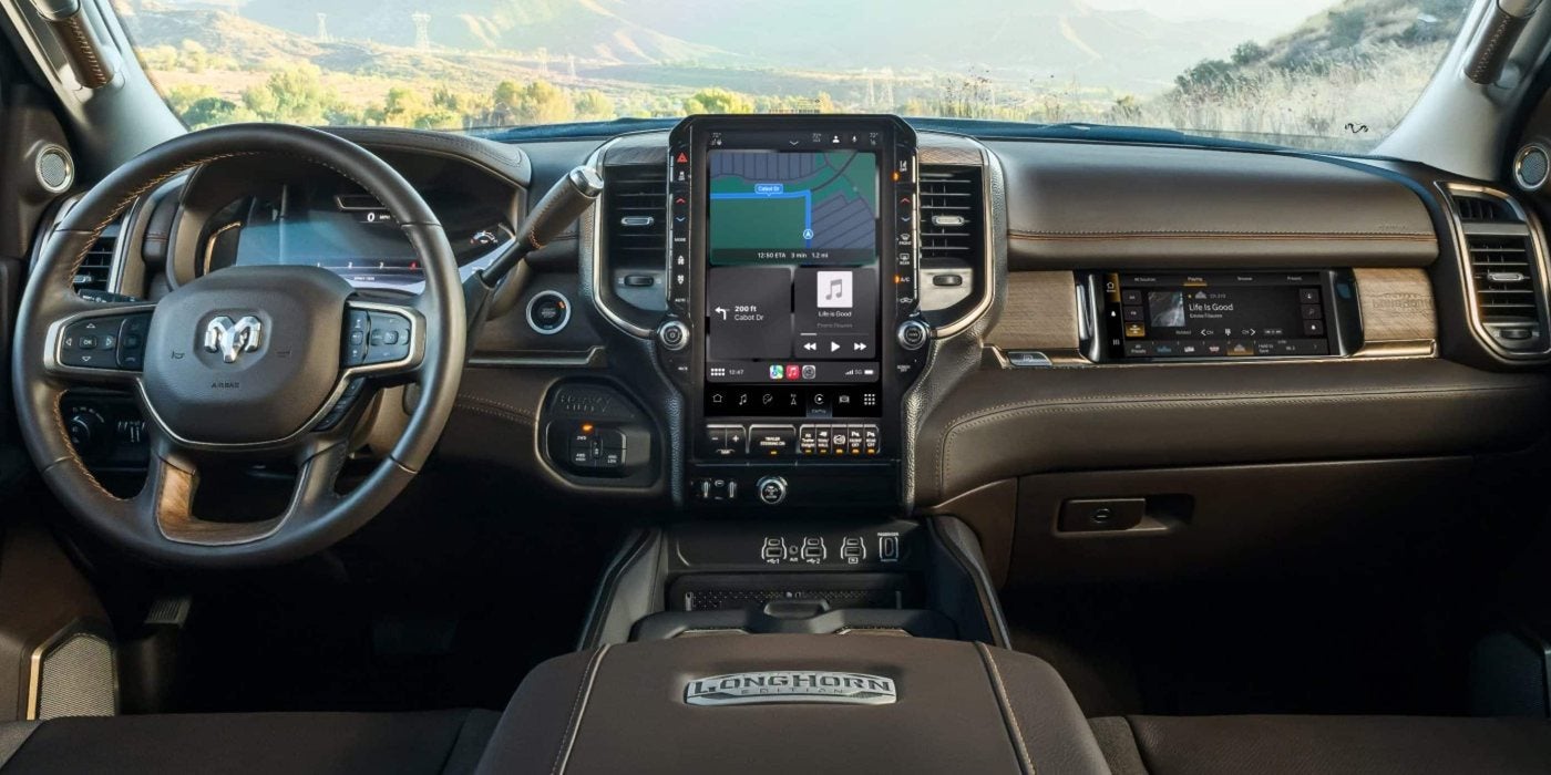 2027 Ram 3500 Limited Longhorn dashboard with a vertical Uconnect touchscreen and front passenger display, at Ross Downing CDJR of Mobile, AL