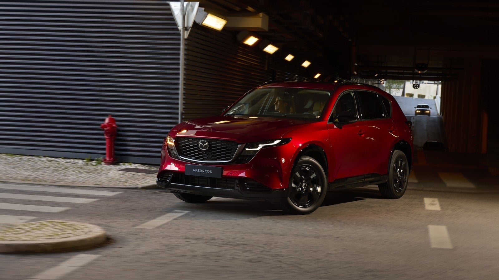Red Mazda CX-5 driving through an urban tunnel