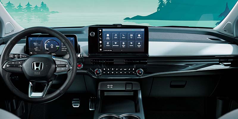 Interior view of a Honda car showing the steering wheel, digital instrument cluster, and a central touchscreen display on the dashboard.