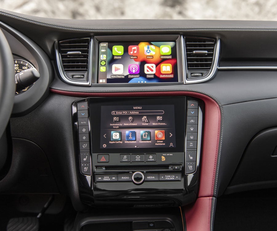 INFINITI QX50 dashboard featuring two touchscreens, air vents, and various buttons set into a dark gray and red console.