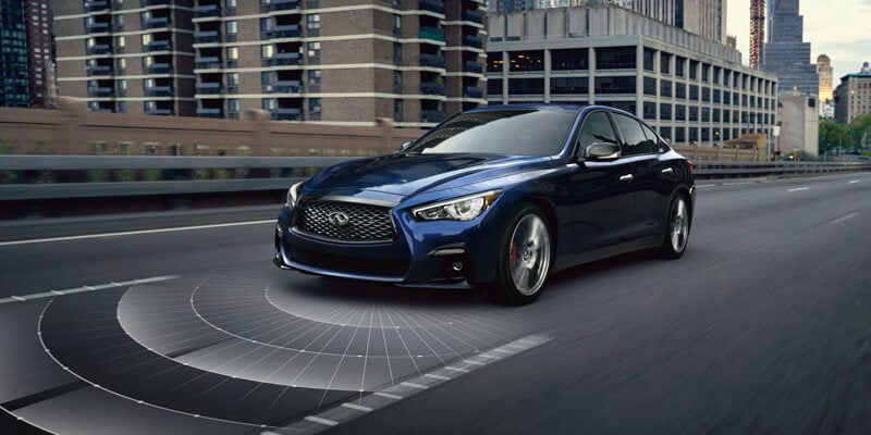 A dark blue INFINITI Q50: Best Vehicles for Seniors driving on a city highway, with a graphical overlay.
