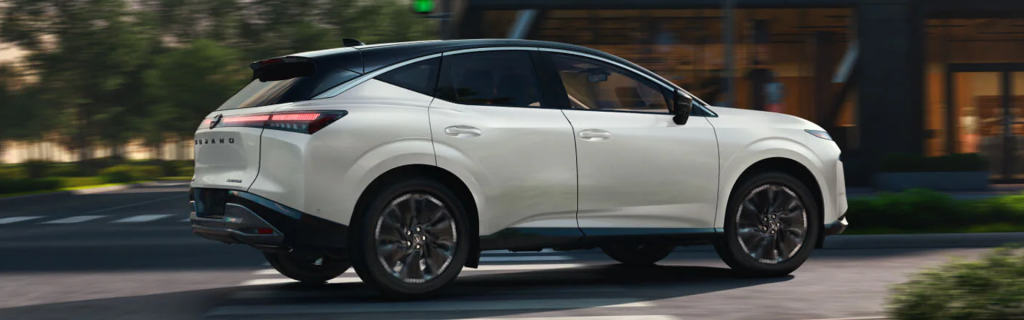 White Nissan Murano driving on a city street.