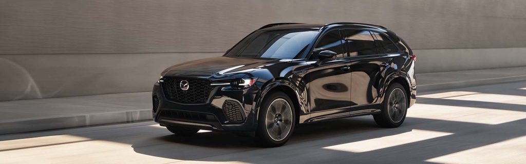 Black Mazda CX-70 driving through a concrete tunnel.