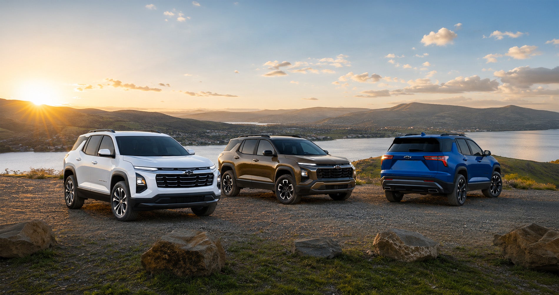 White, bronze, and blue 2027 Chevy Equinox SUVs parked on scenic overlook at sunset, displaying full trim range and color options.