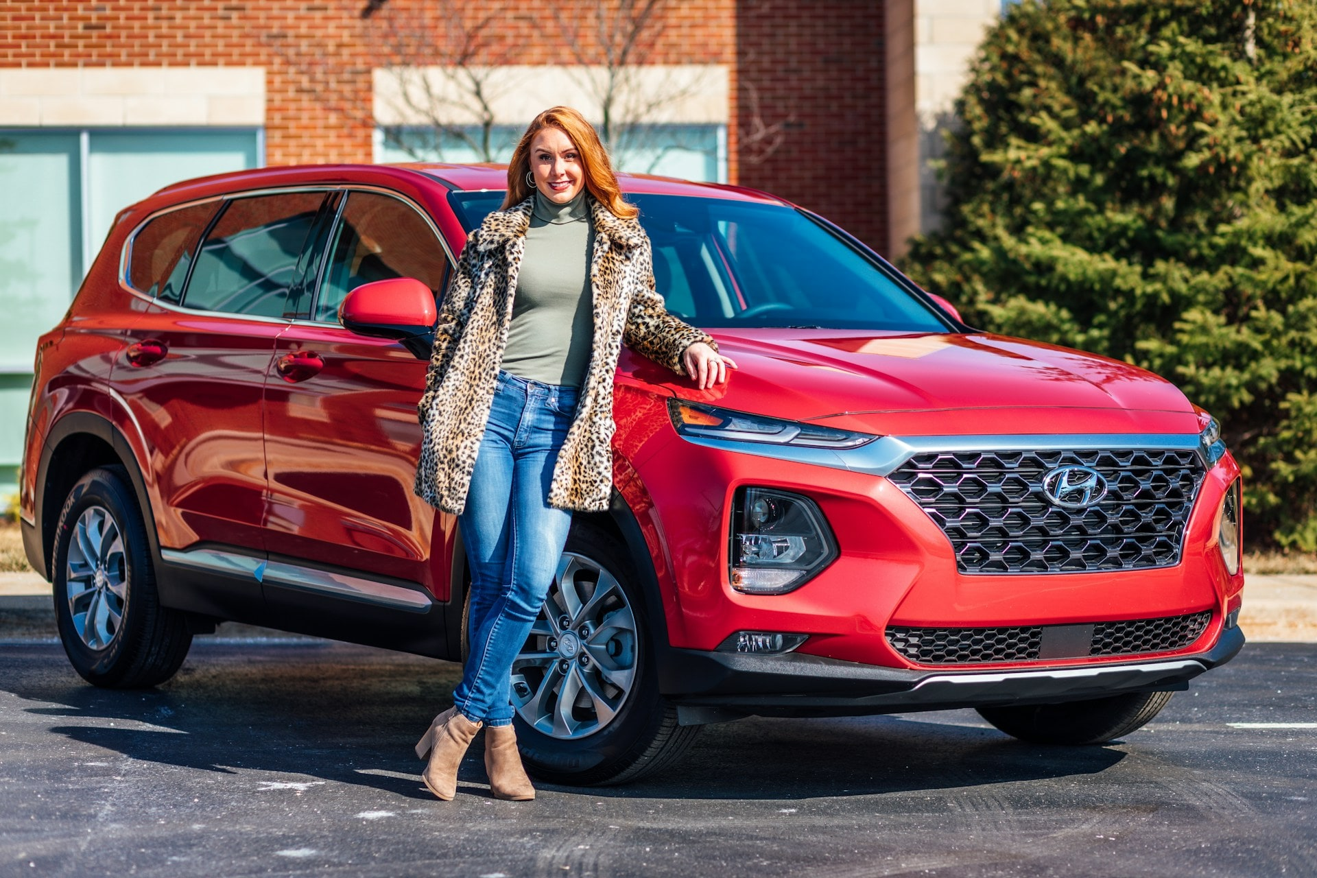 Girl is standing beside Red Hyundai.