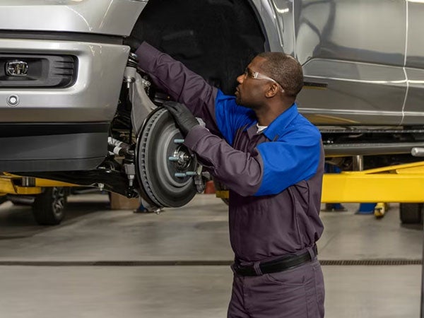 Ford Service Tech Inspecting Vehicle